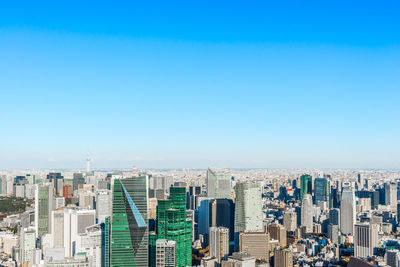 Aerial view of modern buildings against clear blue sky