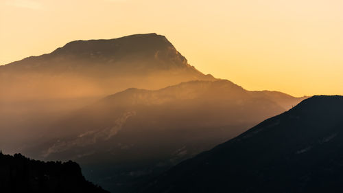 Scenic view of silhouette mountains against sky during sunset