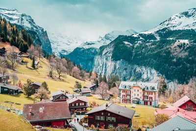 Houses on snowcapped mountain against sky