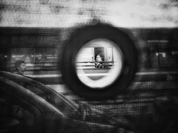 Reflection of people on side-view mirror of car