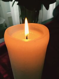 Close-up of lit candle in dark room