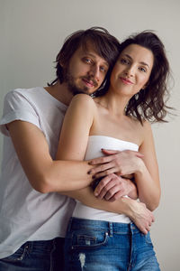 Guy and a girl on a white background in the studio are happy with life