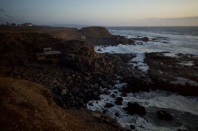 Scenic view of rocks on beach against sky