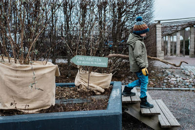 Boy gardening walking through a swedish garden in winter