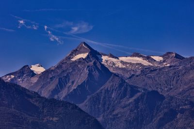 Scenic view of snowcapped mountains against blue sky