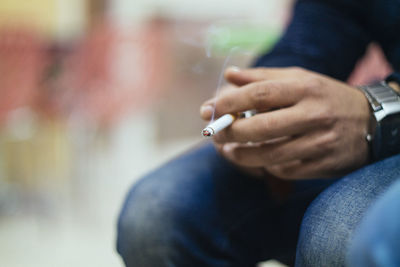 Close-up of smoking man hand