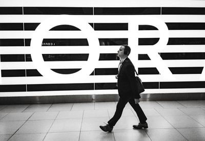 Side view of man walking on tiled floor