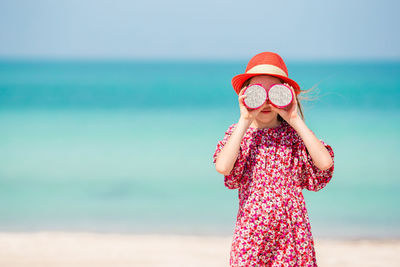 Full length of girl standing against sea