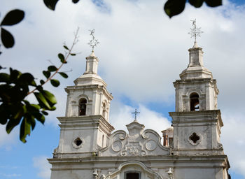 Low angle view of clock tower amidst buildings against sky