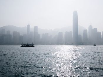 Scenic view of sea and buildings against sky in city