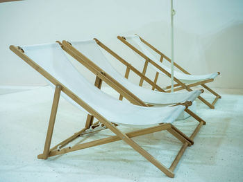 High angle view of empty chair on table against wall
