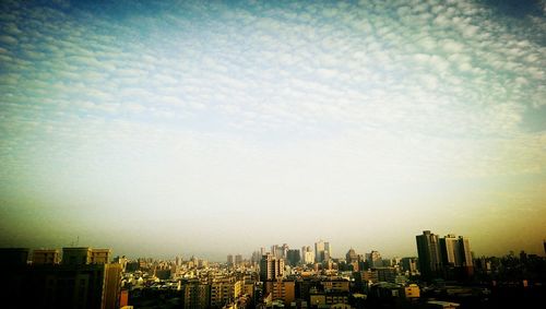 View of cityscape against cloudy sky