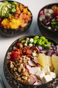 Vertical image close up of poke bowl with fish, rice and fresh vegetables