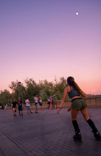 Group of people against clear sky during sunset