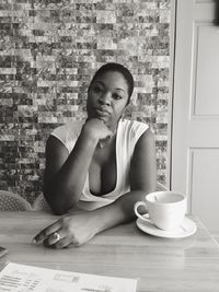 Portrait of young woman sitting on wall