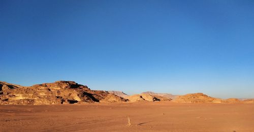 Scenic view of desert against clear blue sky