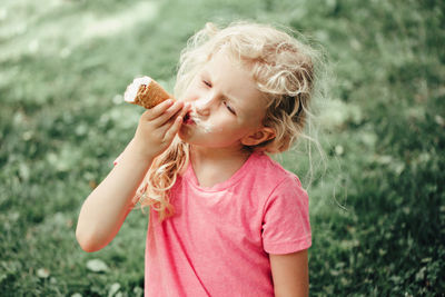 Cute girl eating ice cream at park