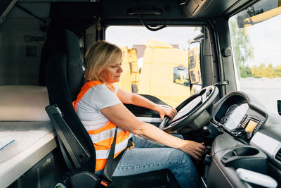 Side view of woman sitting in truck