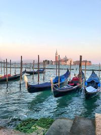 Gondola moored in grand canal against sky