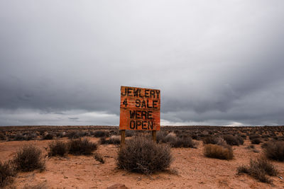 Information sign at monument valley against cloudy sky in arizona