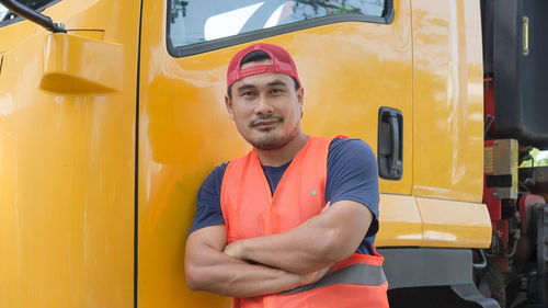 Portrait of young man standing in car