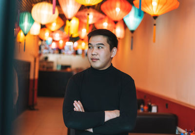 Handsome young asian man in black clothes in festive chinese vietnamese restaurant