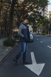 Young man walking on road in city