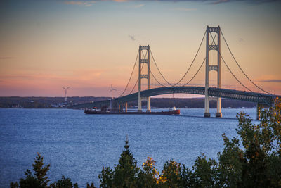 Bridge over river against sky during sunset