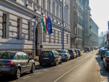 Cars on road by buildings in city