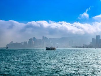 Scenic view of sea by buildings against sky