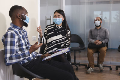 Candidate wearing mask sitting for interview at office