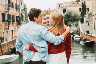 Couple standing on canal in city