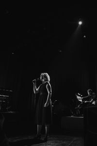 Woman standing in illuminated stage