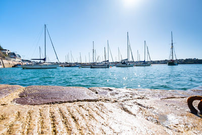 Sailboats sailing in sea against clear sky