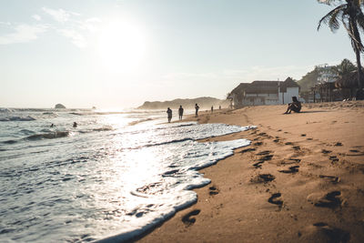 People on beach against sky