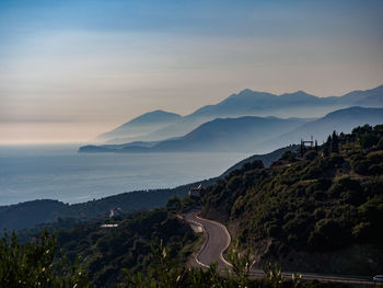 Scenic view of sea and mountains against sky during sunset