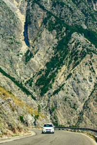 Car moving on road by mountain