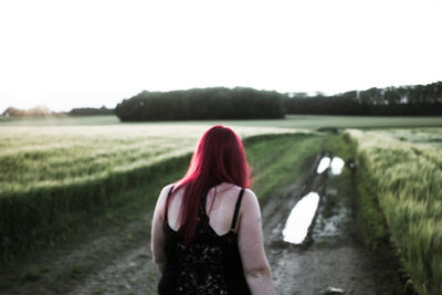 Rear view of woman walking in field