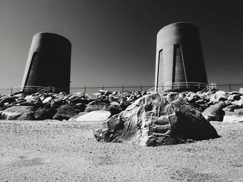 Smoke stack on beach against clear sky