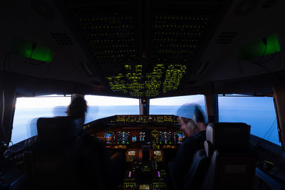 Rear view of man looking through airplane window