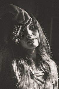 Portrait of young woman holding a vintage camera 