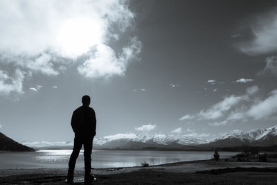 Rear view of silhouette man standing on beach