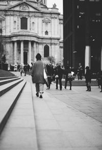 Rear view of people walking on street in city