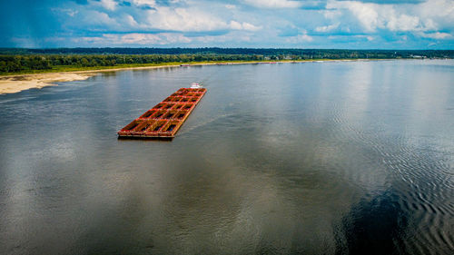 Approaching an empty coal barge on the mississippi river as seen from a drone.