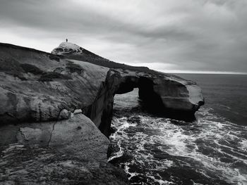 Scenic view of rocks in sea against sky