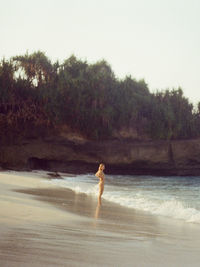 Rear view of woman walking at beach against sky in nusa lembongan. shot on 35mm film. 