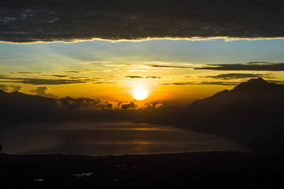 Scenic view of silhouette mountains against romantic sky at sunset