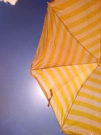 Low angle view of yellow umbrella against sky