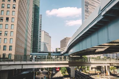 Bridges over street amidst buildings against sky