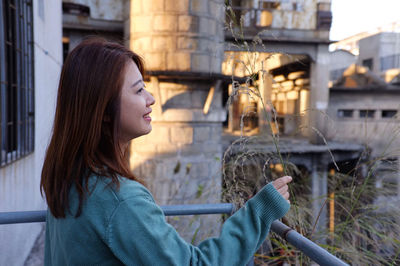 Side view of young woman looking at camera